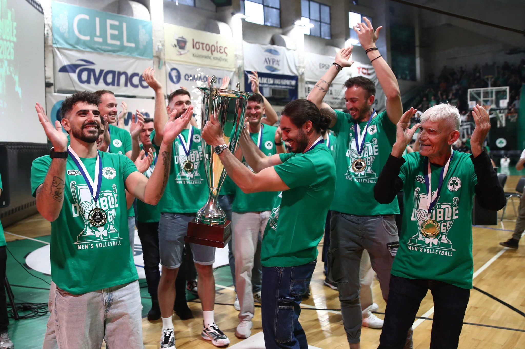 Ο αρχηγός Θανάσης Πρωτοψάλτης με τους συμπαίκτες του και τον Ρούλη Αγραπιδάκη πανηγυρίζουν την κατάκτηση του πρωταθλήματος της Novibet Volley League 2025/26 | Πηγή: Intime